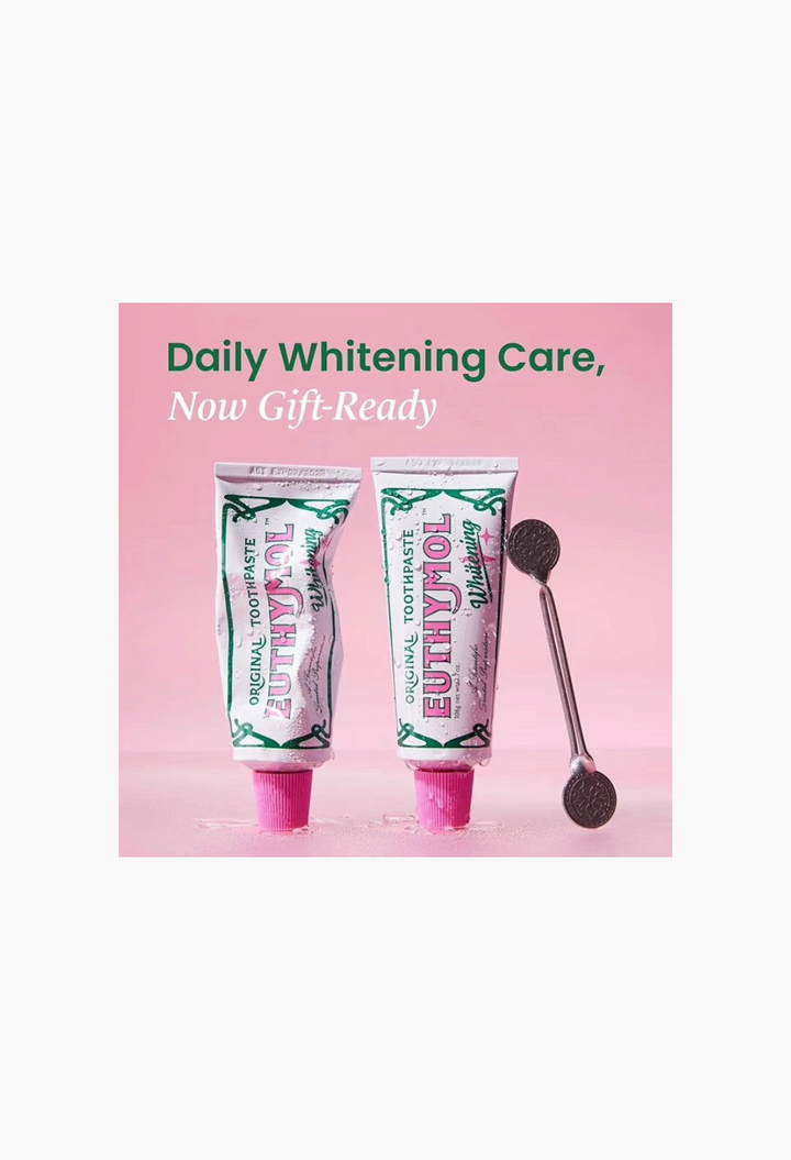 GLAM MODA EUTHYMOL whitening toothpaste gift set with two tubes and a metal squeezer on a pink background