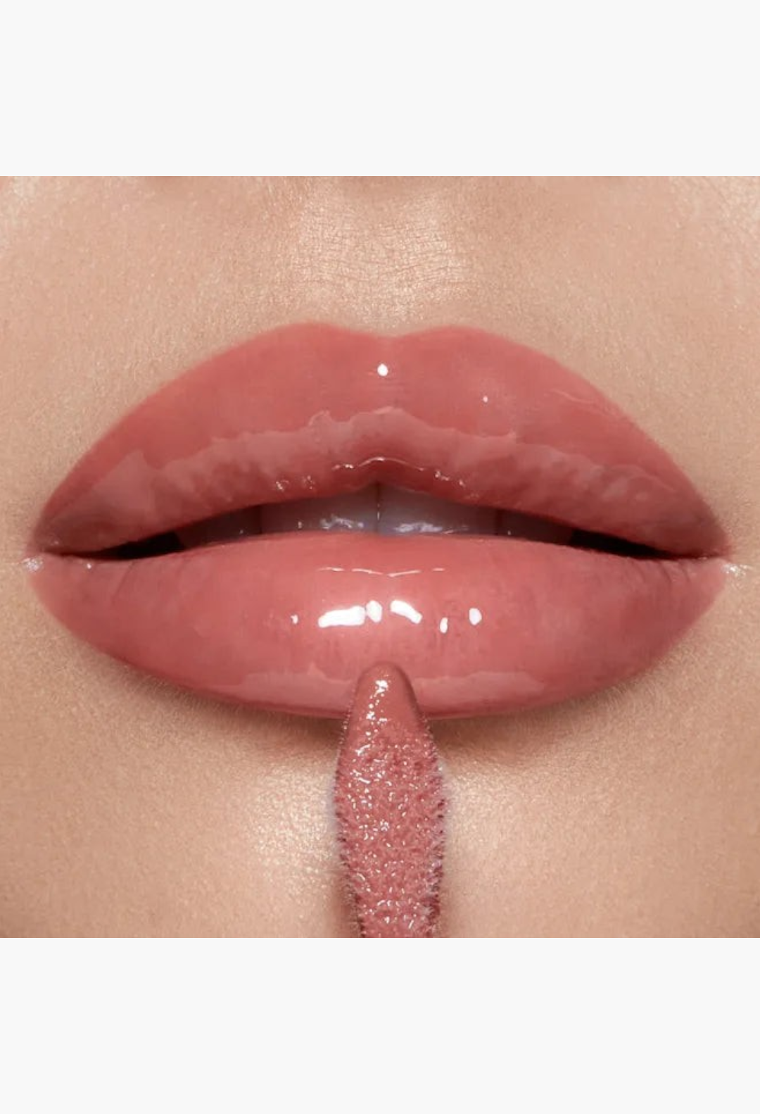 GLAM MODA Pillow Talk makeup set featuring a glossy lip plumper applicator applying a sheer pink shine to the lips.