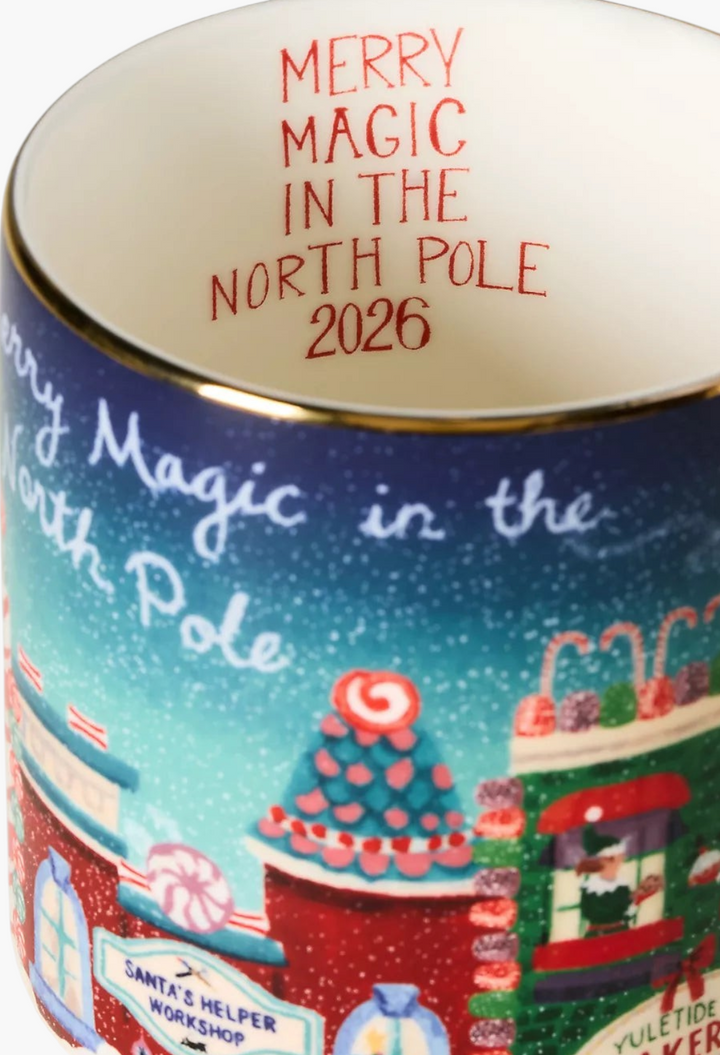 GLAM MODA Holiday in the City stoneware mug featuring a festive North Pole scene with hand-painted gold rim accents.