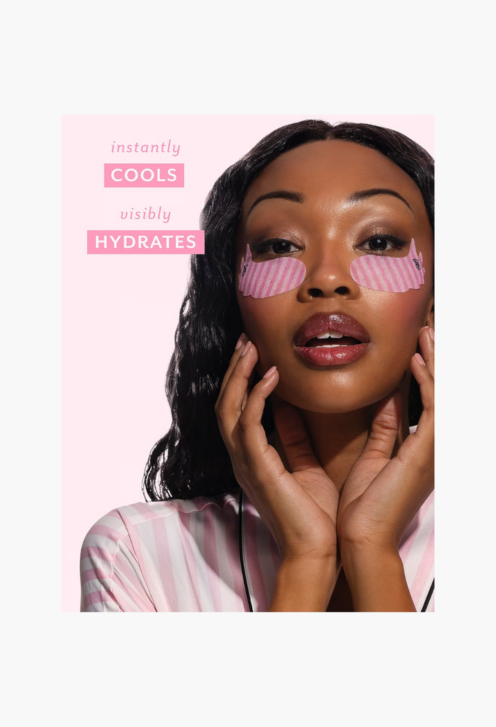 GLAM MODA model wearing pink striped wing-shaped eye patches for hydration and smoothing under the eyes