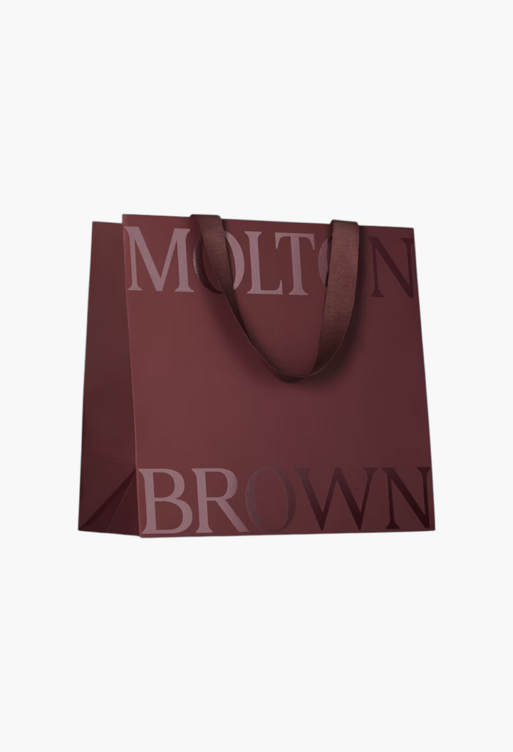 GLAM MODA branded deep red gift bag with dark brown ribbon handles and large embossed lettering