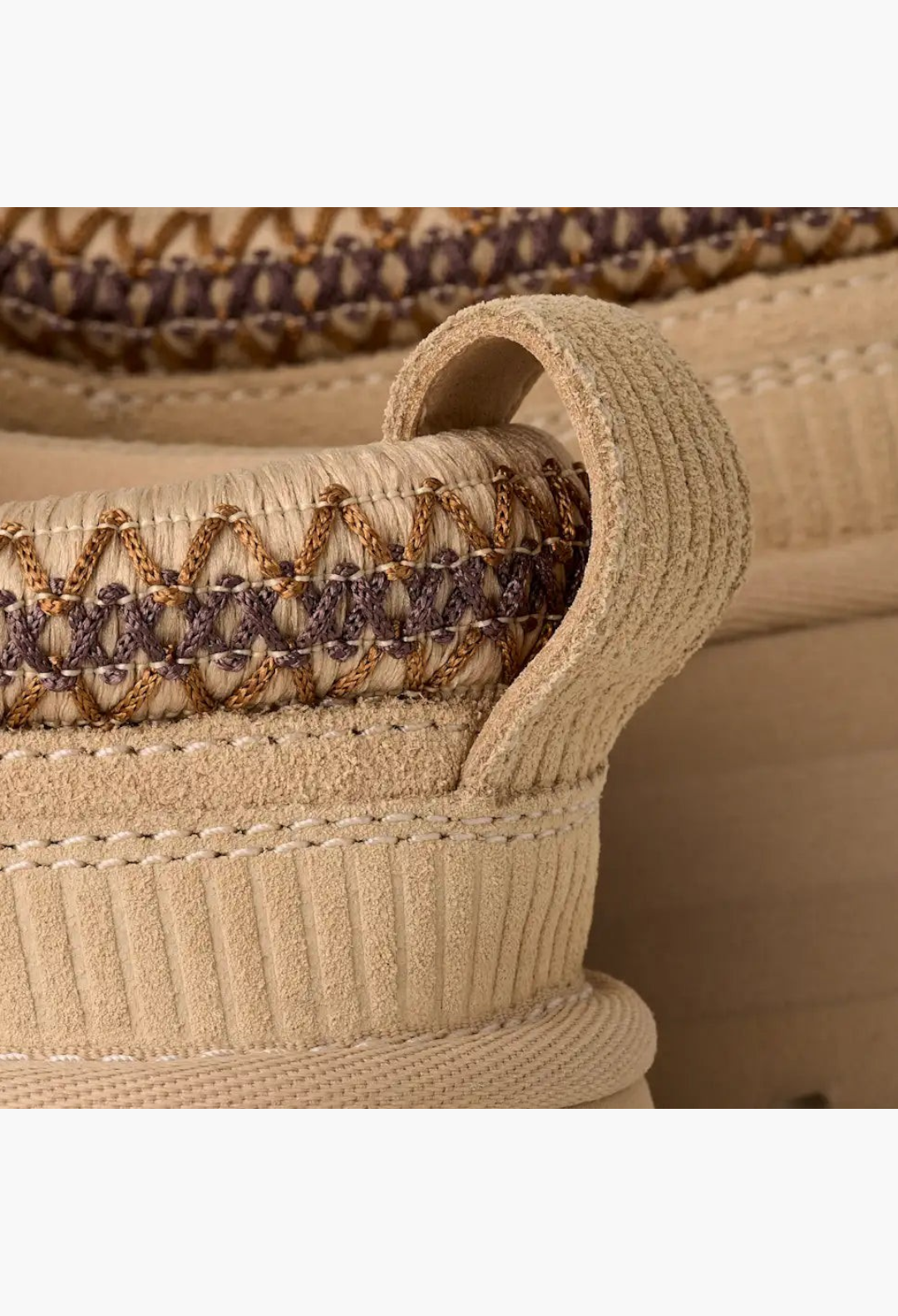 GLAM MODA beige suede slipper featuring decorative UGGbraid trim, rear pull tab, and soft sheepskin lining detail