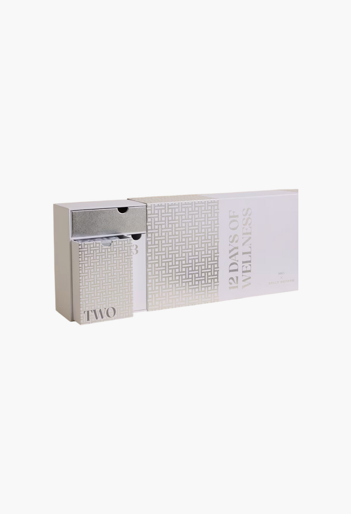 GLAM MODA 12 Days of Wellness advent calendar with white and silver patterned sliding drawers on a neutral background.