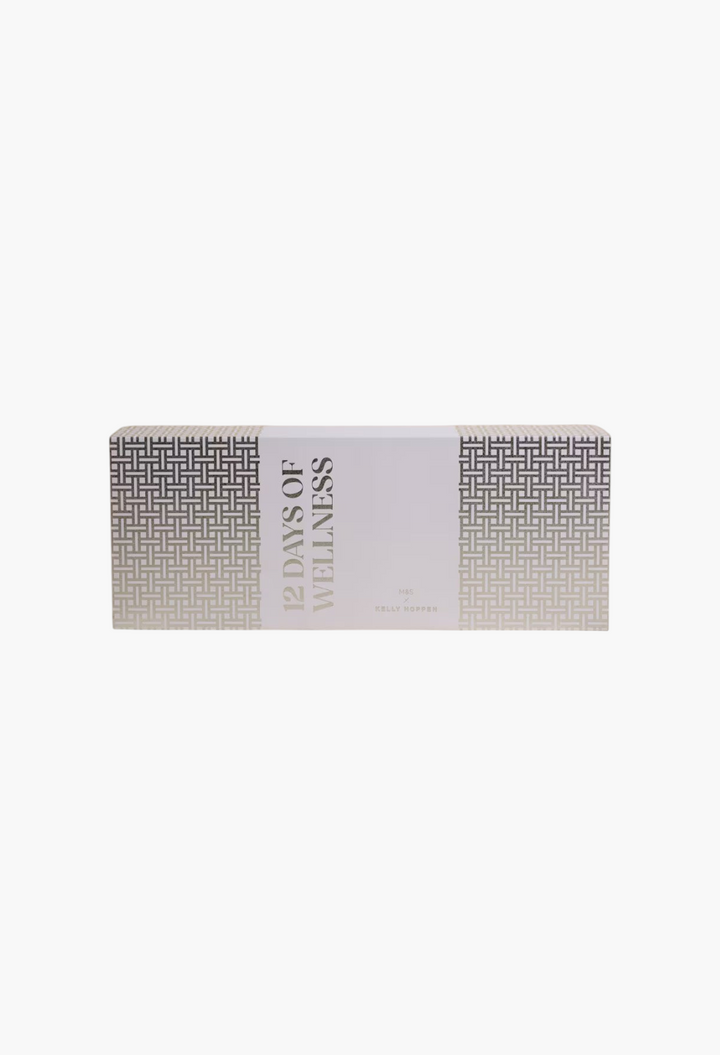 GLAM MODA 12 Days of Wellness advent calendar in a rectangular box with a geometric white and grey pattern.