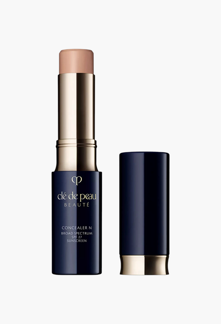 GLAM MODA Concealer SPF 27 stick in a navy blue and gold tube with the cap removed to show the creamy beige formula.