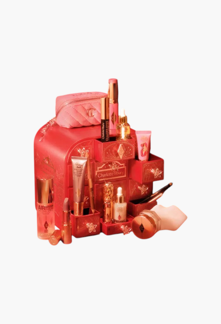 GLAM MODA Charlotte Tilbury Hollywood beauty advent calendar with red star-adorned drawers and assorted makeup products.