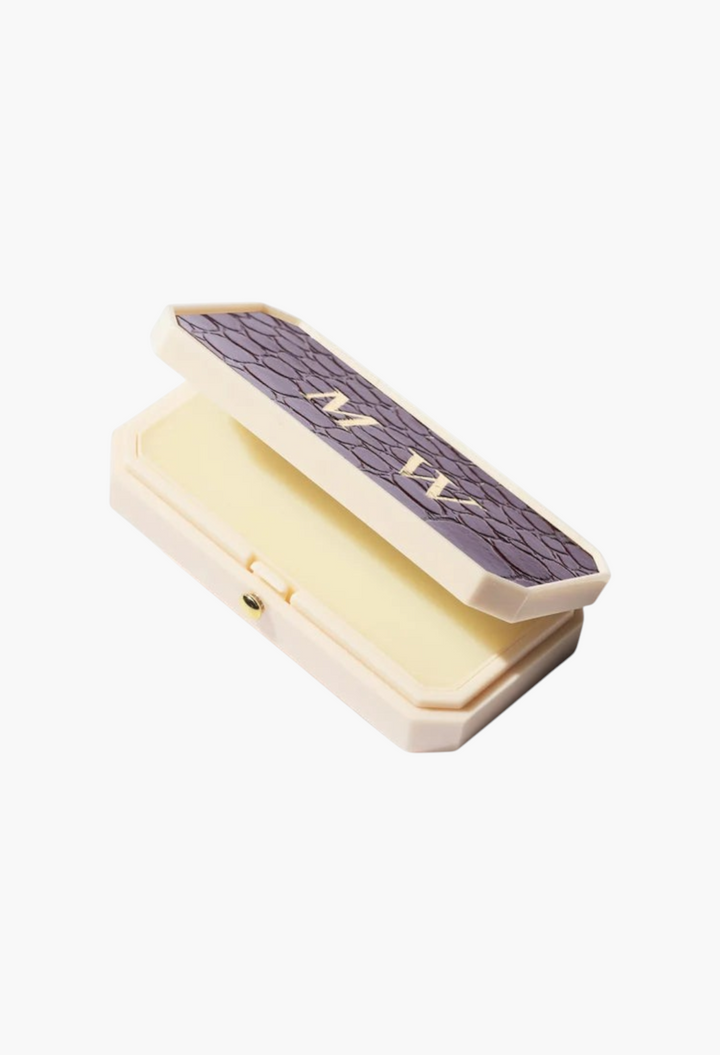 GLAM MODA Baume des Muses Ivory lip balm in a vintage-style box with a textured purple lid and gilt initials.