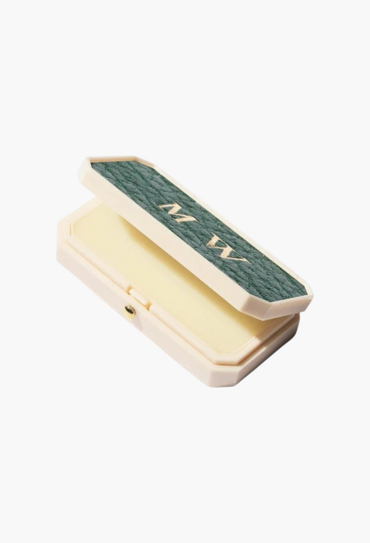 GLAM MODA Baume des Muses Ivory lip balm in a customizable ivory case with a green textured lid and gold initials