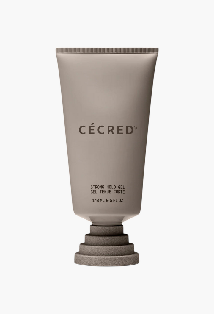 GLAM MODA CÉCRÉD Strong Hold Gel in a beige squeeze tube with a unique tiered base against a black background.