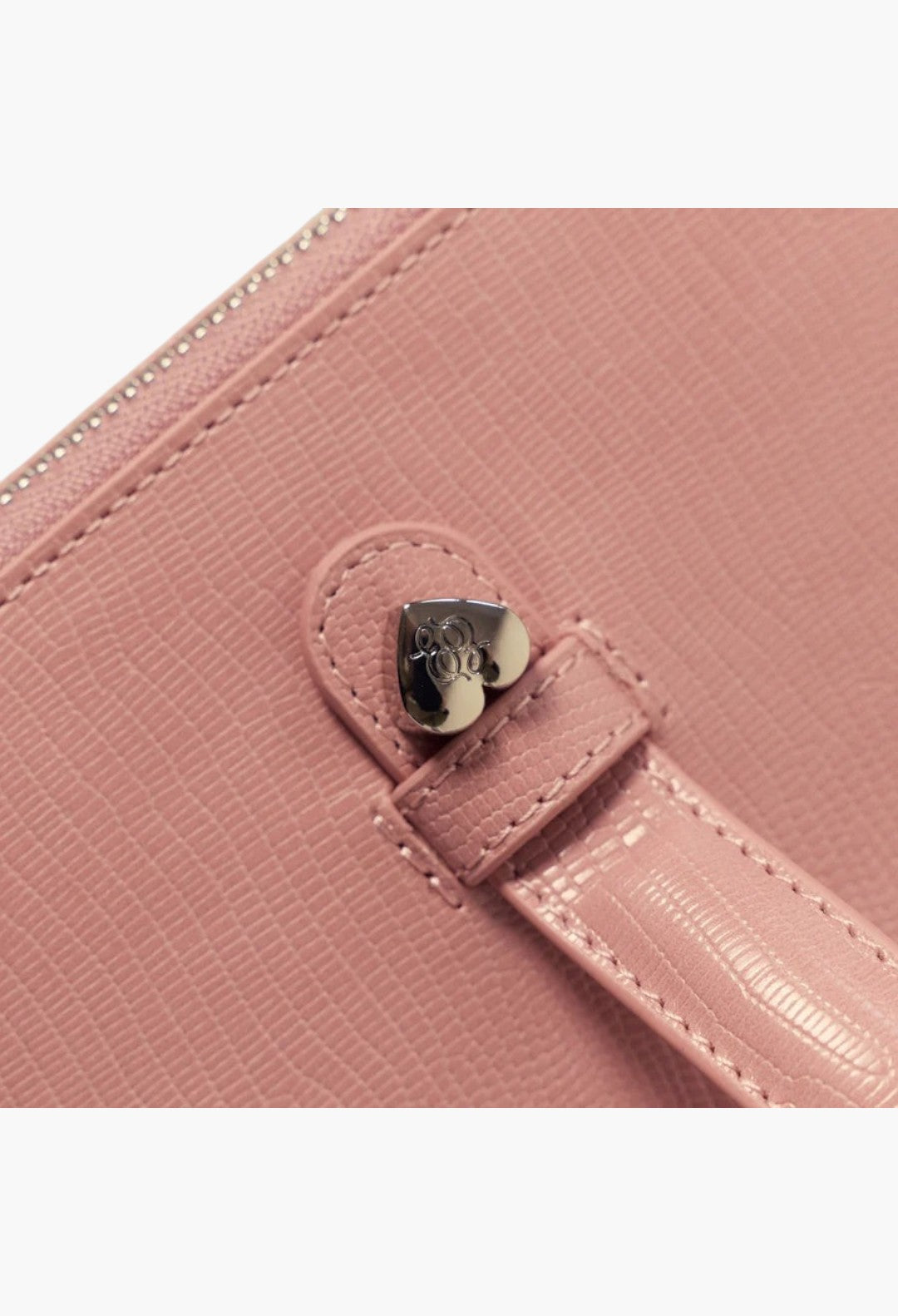 GLAM MODA pink vegan leather oval toiletry case featuring a heart-shaped metal charm on the handle attachment.