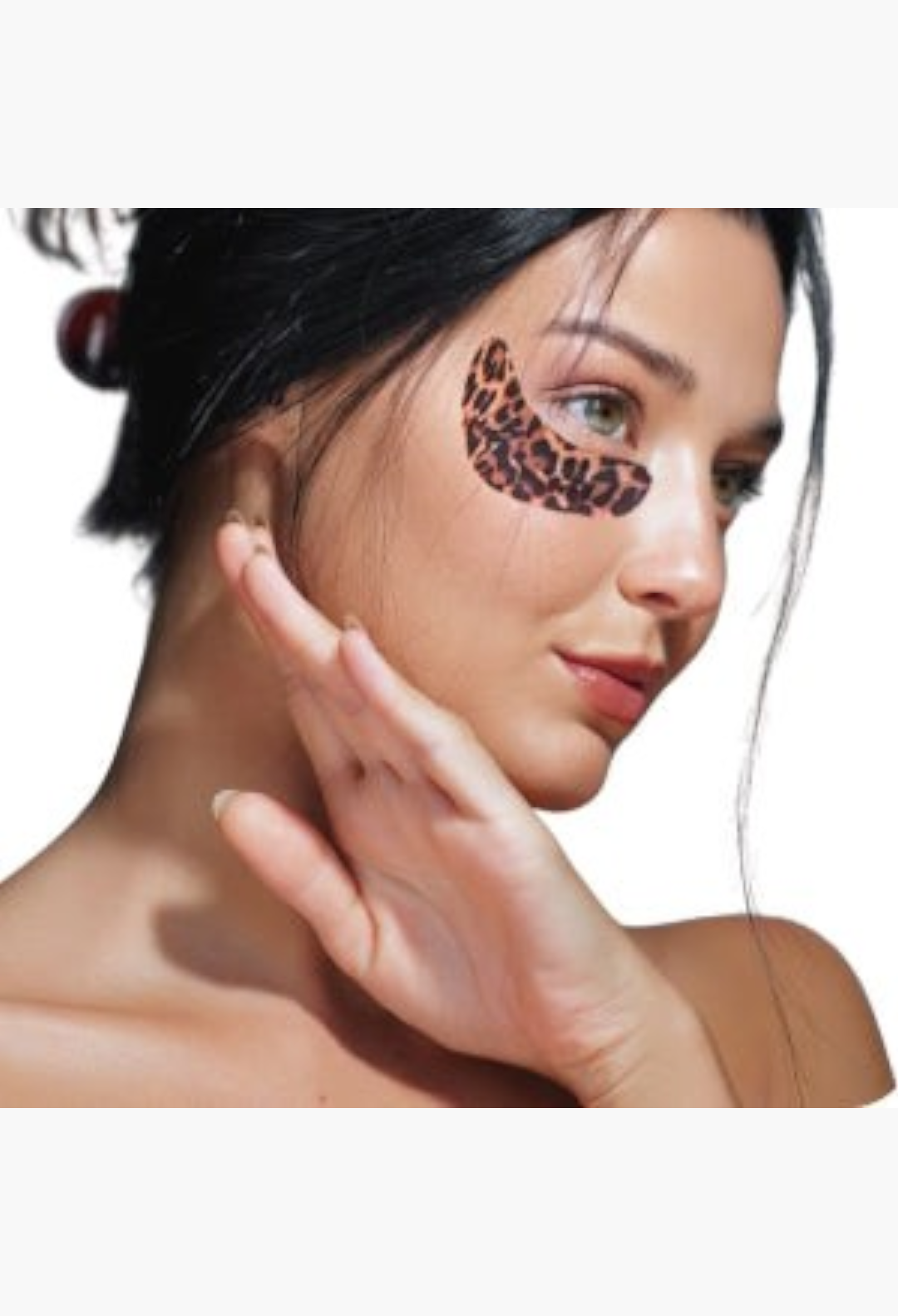 GLAM MODA leopard print eye therapy patches applied under the eye of a woman to reduce puffiness and dark circles