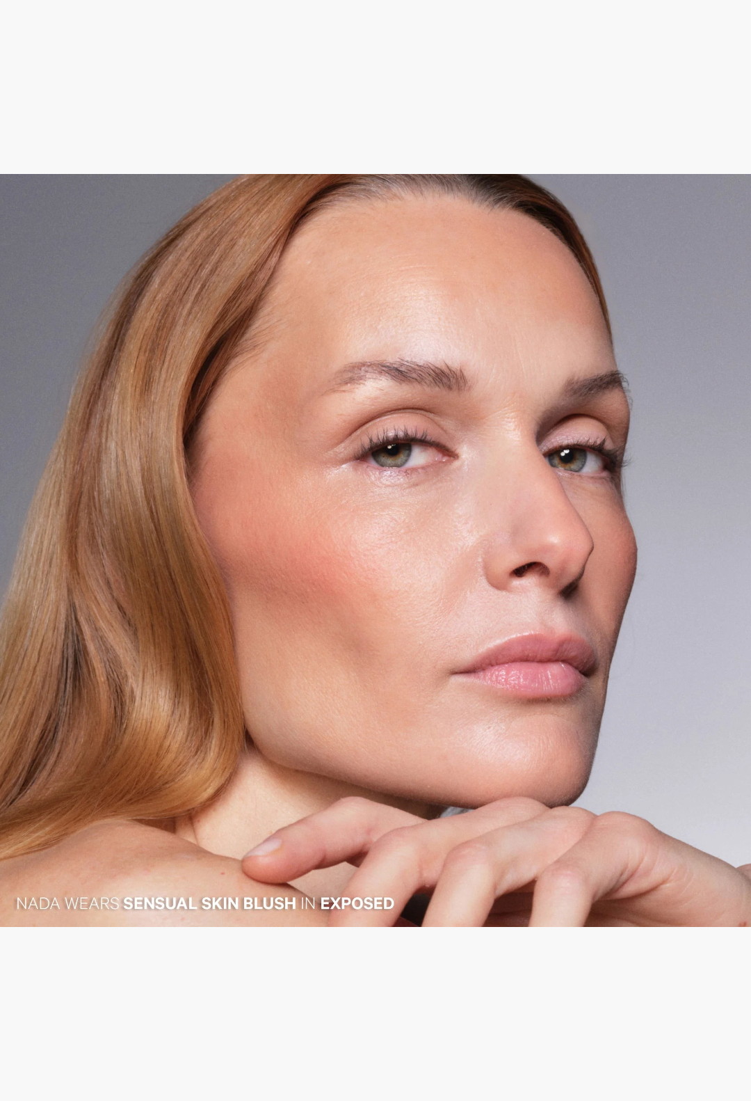Model wearing GLAM MODA Sensual Skin Blush in Exposed, a neutral peach cream-to-powder formula for a soft-focus finish