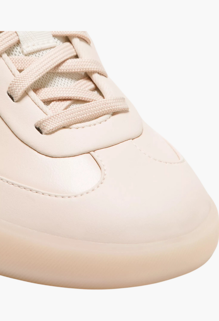 Close-up of GLAM MODA Cityverse sneaker in cream with leather-alternative upper, exposed stitching, and rubber sole.