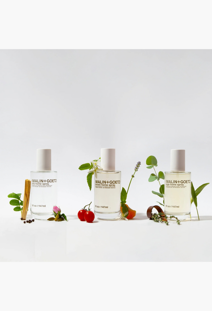 GLAM MODA Otto home spray bottles displayed with fresh botanicals and spices on a white background.