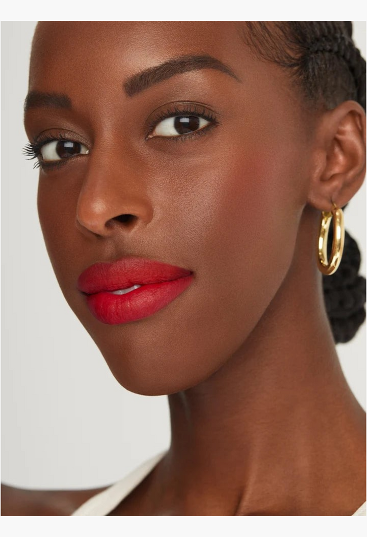 GLAM MODA Kind Words Matte Lip Liner in Devoted true red on a model with gold hoop earrings
