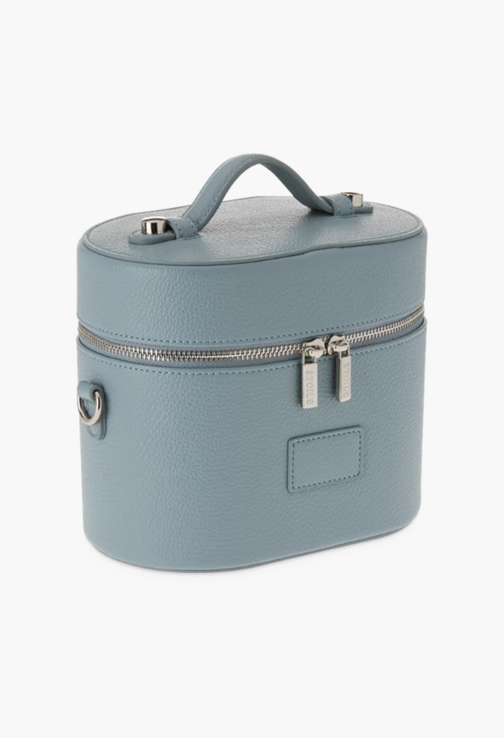 GLAM MODA oval toiletry case in blue vegan leather with a top handle, dual zipper closure, and shoulder strap rings.