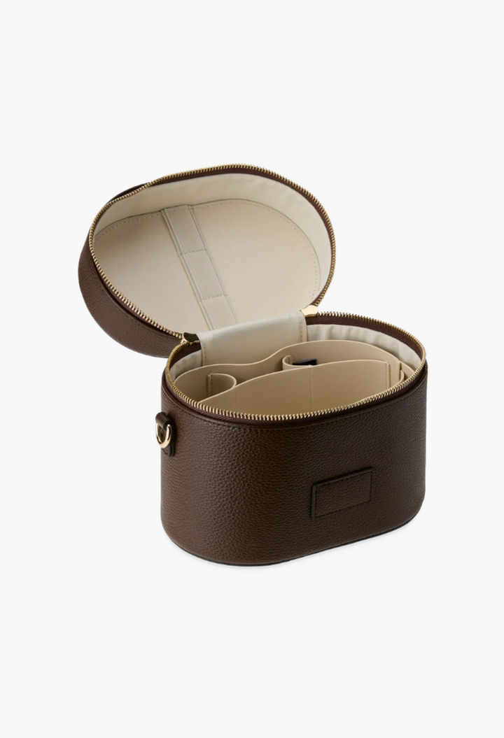 GLAM MODA brown vegan leather oval toiletry case with open lid, removable divider, and internal elastic brush loops.