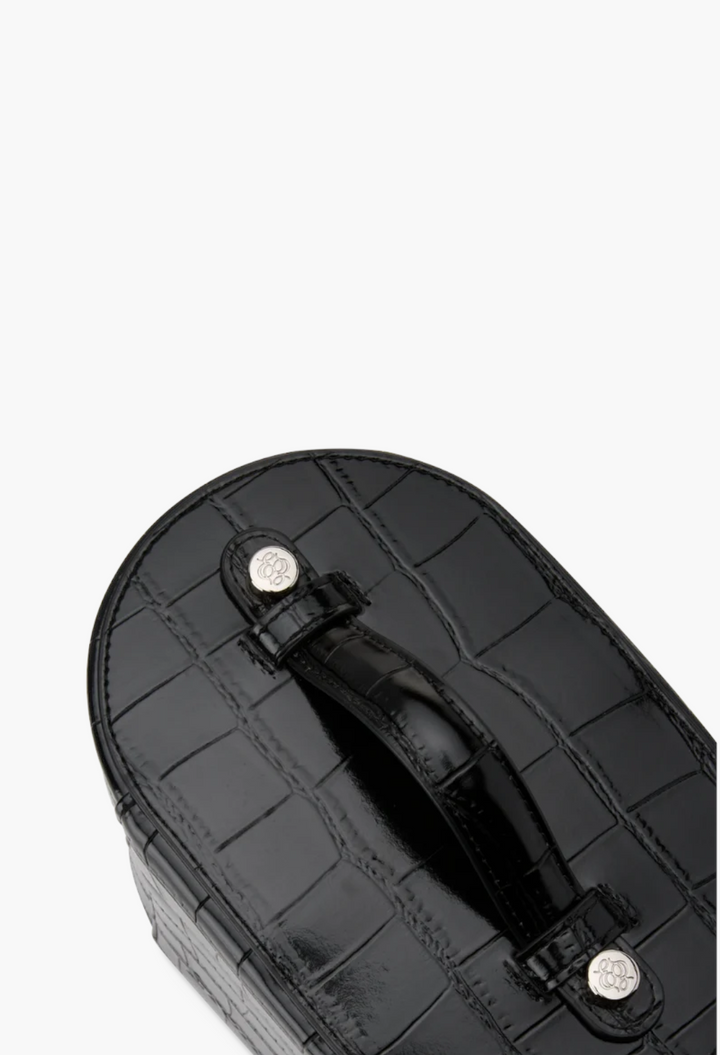 GLAM MODA oval toiletry case in black croc-embossed vegan leather with a top handle and silver hardware details.