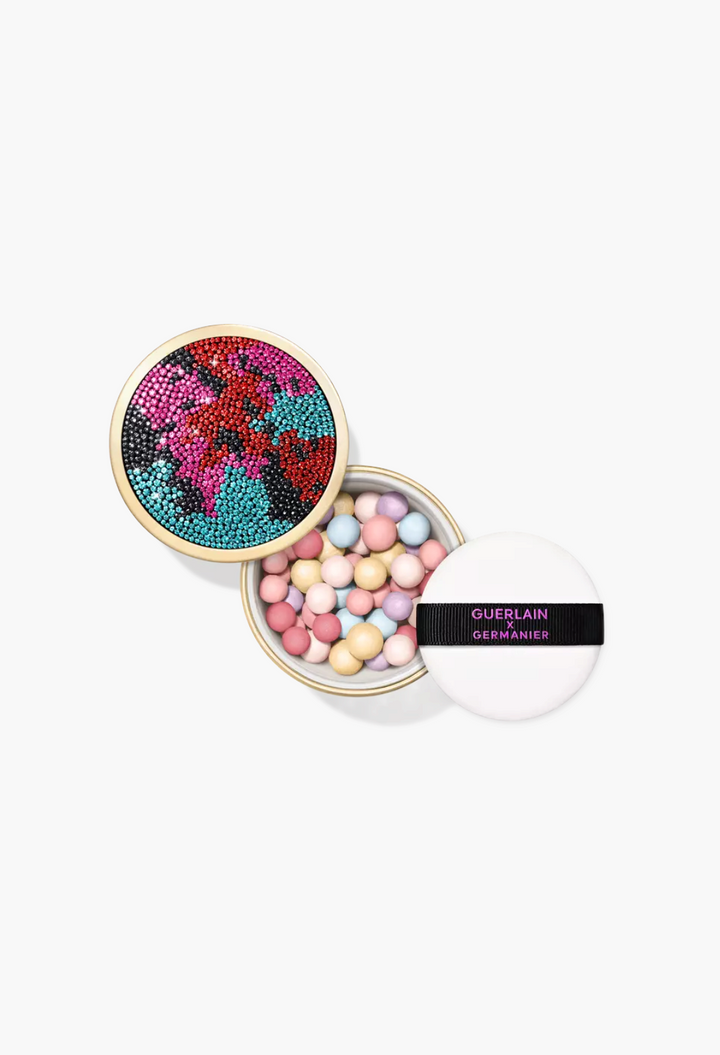 GLAM MODA Météorites setting powder pearls in a rhinestone-encrusted gold case with a branded white powder puff