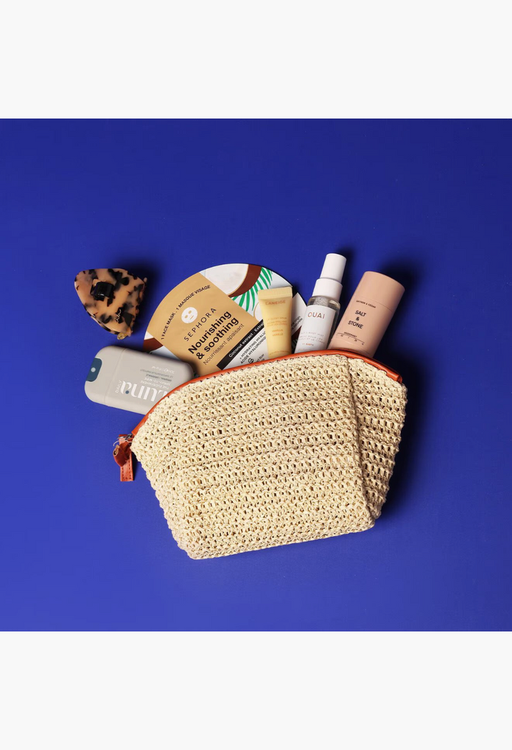 GLAM MODA The Beauty Reset kit featuring skincare, hair, and body wellness products inside a beige woven cosmetic bag.