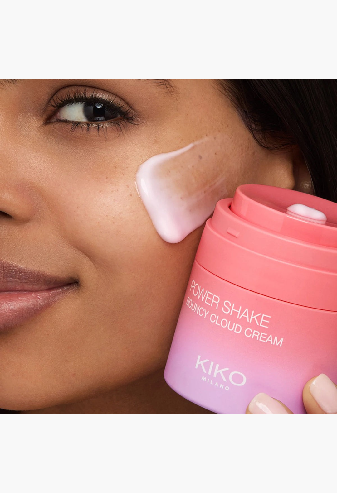 GLAM MODA Kiko Milano Power Shake Bouncy Cloud Cream applied to a model's cheek with a pink gradient jar