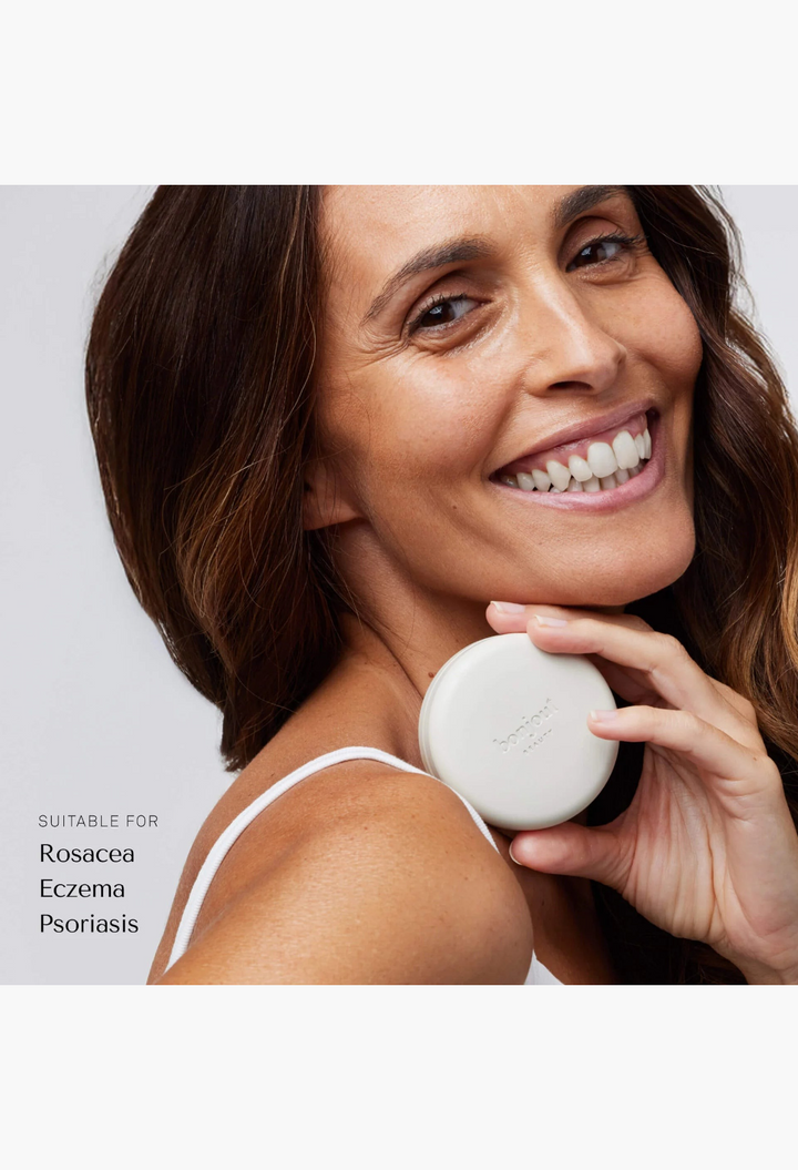 GLAM MODA Le Balm Duo unscented solid serum held by a smiling woman to soothe and repair sensitive skin