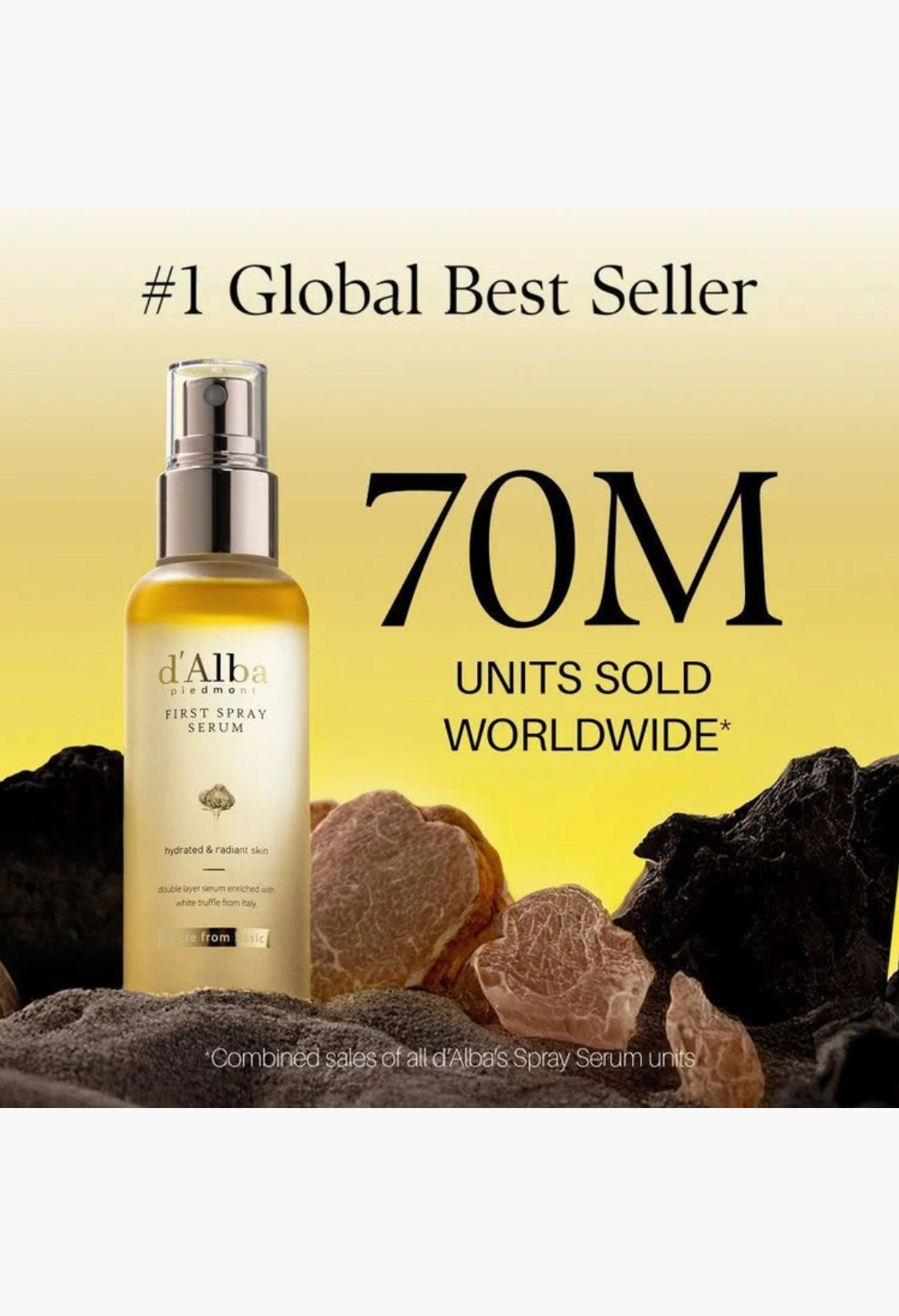 GLAM MODA d'Alba White Truffle First Spray Serum bottle with golden liquid, surrounded by truffles and dark sand.