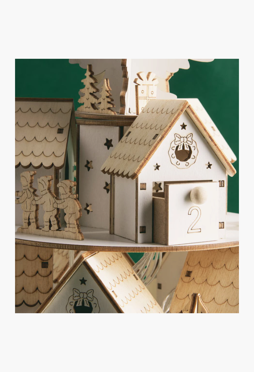 GLAM MODA tiered 3D wooden advent calendar featuring miniature houses with numbered drawers and festive details.