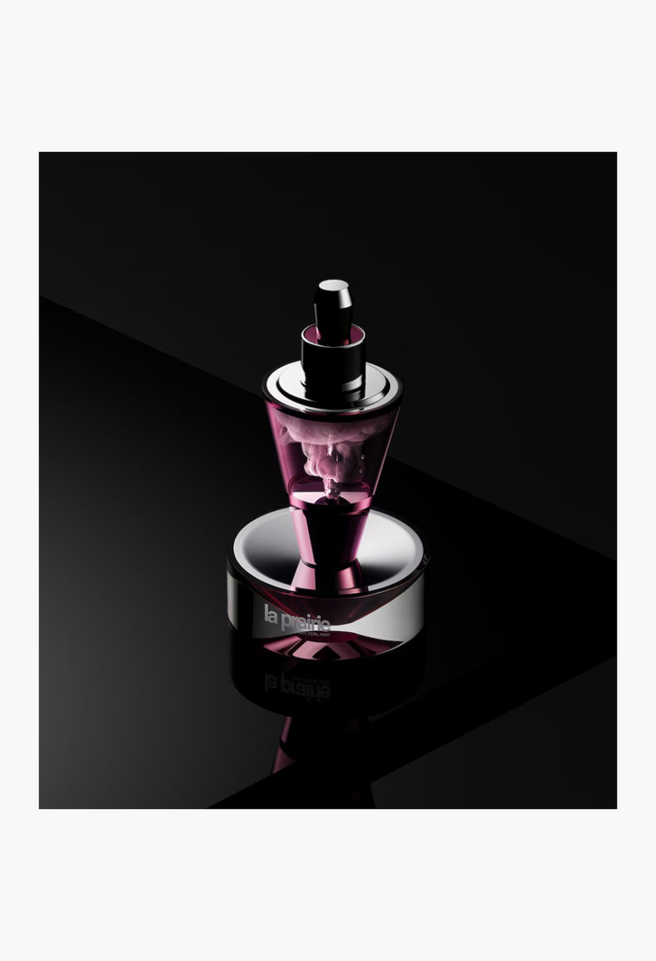 GLAM MODA La Prairie Platinum Rare Haute-Rejuvenation Protocol serum vial in a sleek purple and metallic display stand.