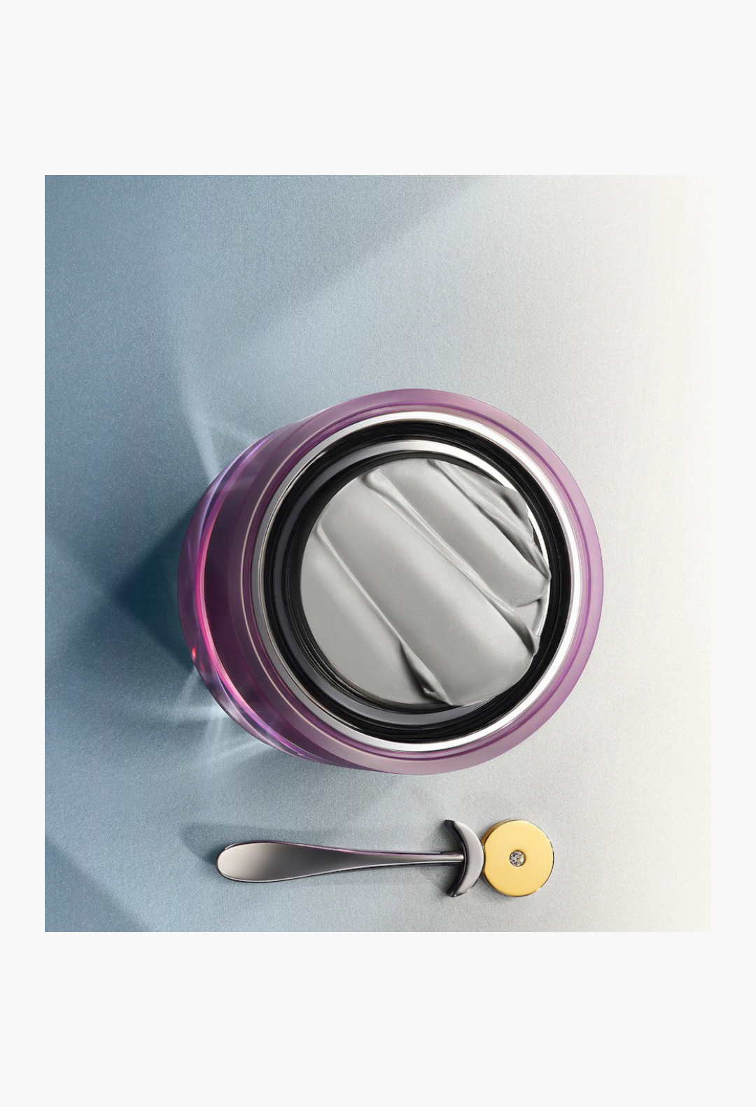 GLAM MODA Platinum Rare Haute-Rejuvenation Cream in a purple jar with a silver spatula on a white background.