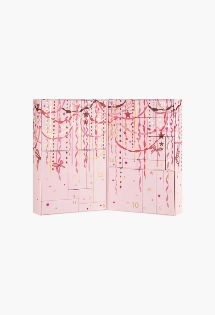 GLAM MODA 24 Days of Skin advent calendar in light pink with festive gold and red ribbon and star illustrations.