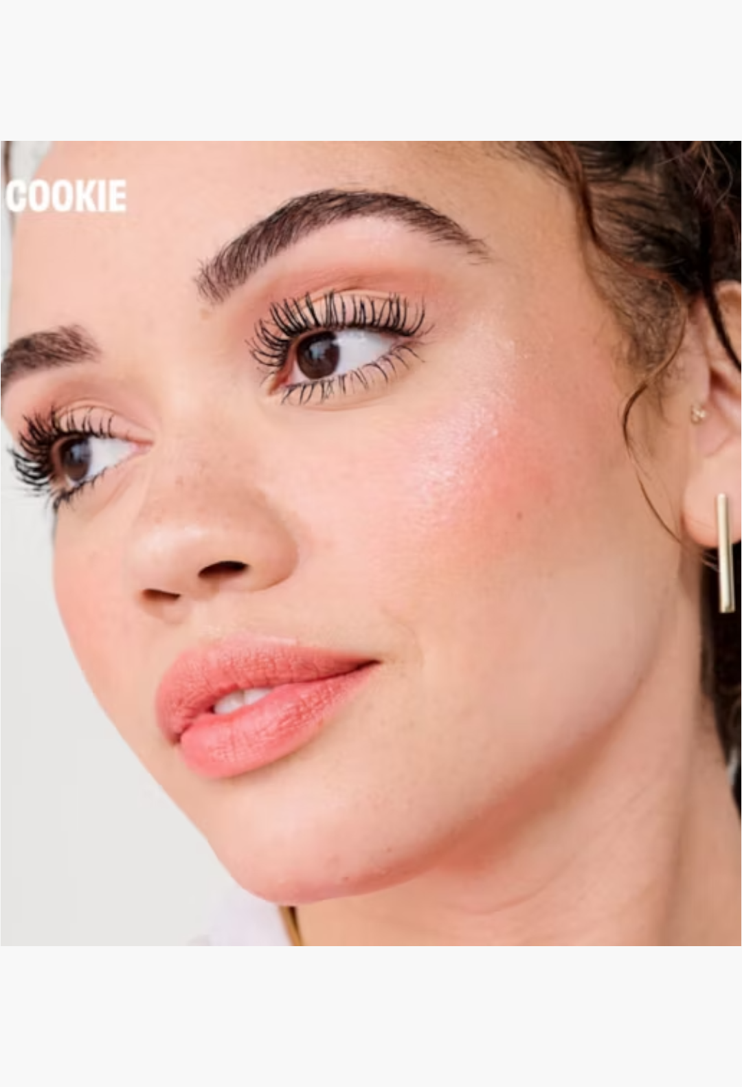 GLAM MODA model wearing Benefit Cookie golden pearl highlighter and mascara for a radiant makeup look