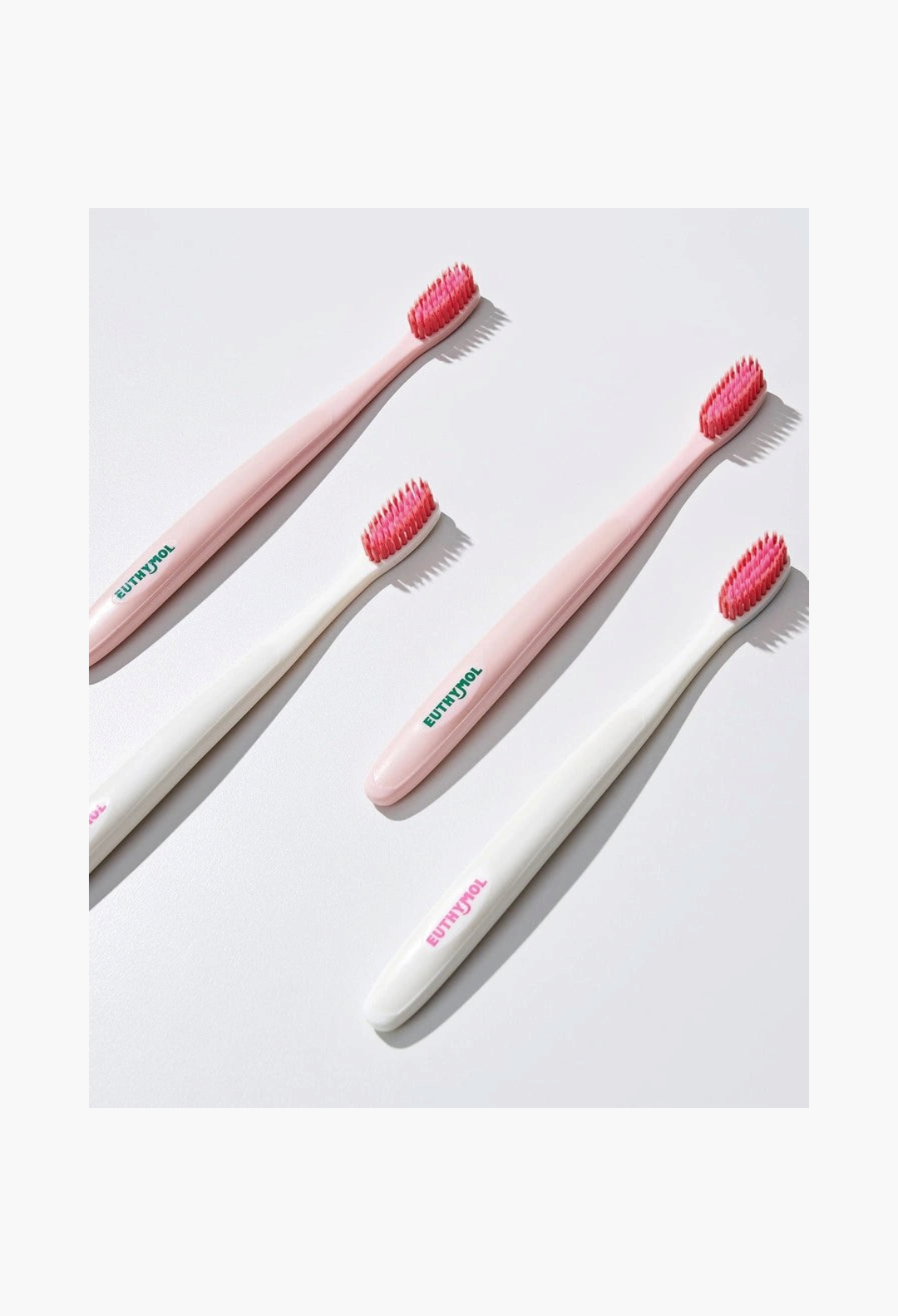 GLAM MODA Euthymol whitening toothbrushes with pink bristles and white or light pink handles on a white background