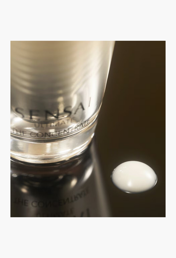 GLAM MODA Sensai Ultimate The Concentrate anti-ageing essence bottle with a drop of white nectar-like serum on surface