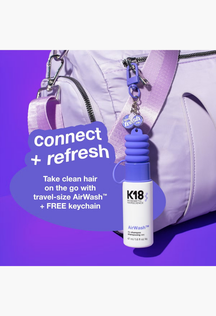 GLAM MODA K18 AirWash dry shampoo mini spray with a collectible keychain attached to a light purple travel bag