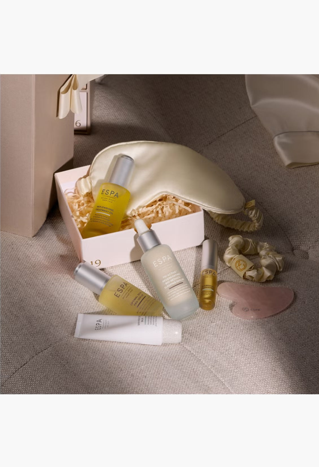 GLAM MODA ESPA Moments of Wellness Advent Calendar featuring skincare bottles, silk eye mask, scrunchie, and gua sha tool.