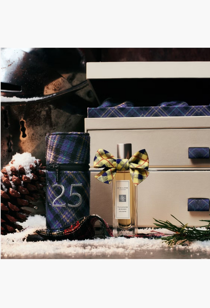 GLAM MODA Jo Malone London Tangerine & Honey cologne bottle adorned with a festive yellow and blue plaid ribbon bow.