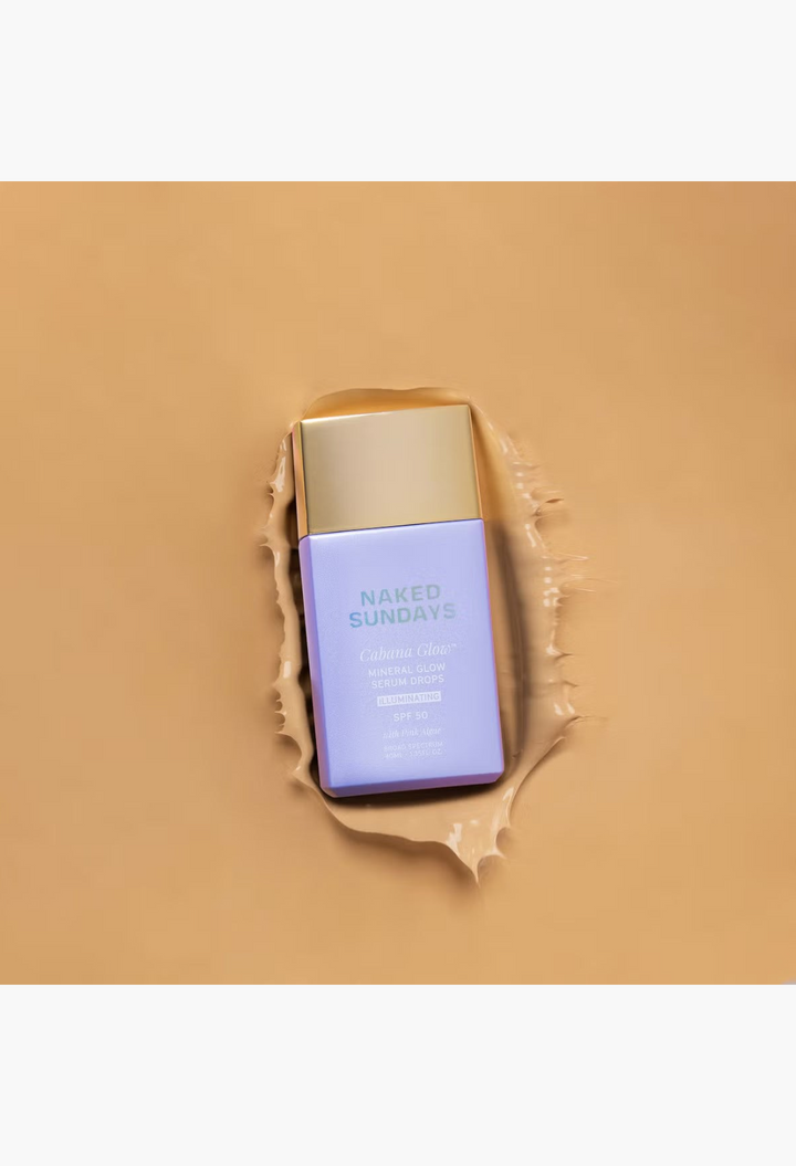 GLAM MODA Naked Sundays Cabana Glow SPF50 illuminating mineral serum drops in a lavender bottle on a tan background.