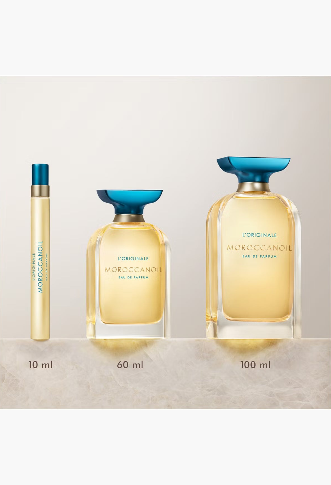 GLAM MODA Moroccanoil L'Originale Eau de Parfum collection in 10ml, 60ml, and 100ml glass bottles with blue caps.