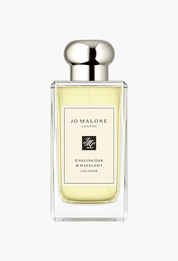 GLAM MODA Jo Malone London English Oak & Hazelnut cologne in a clear glass bottle with a silver cap.