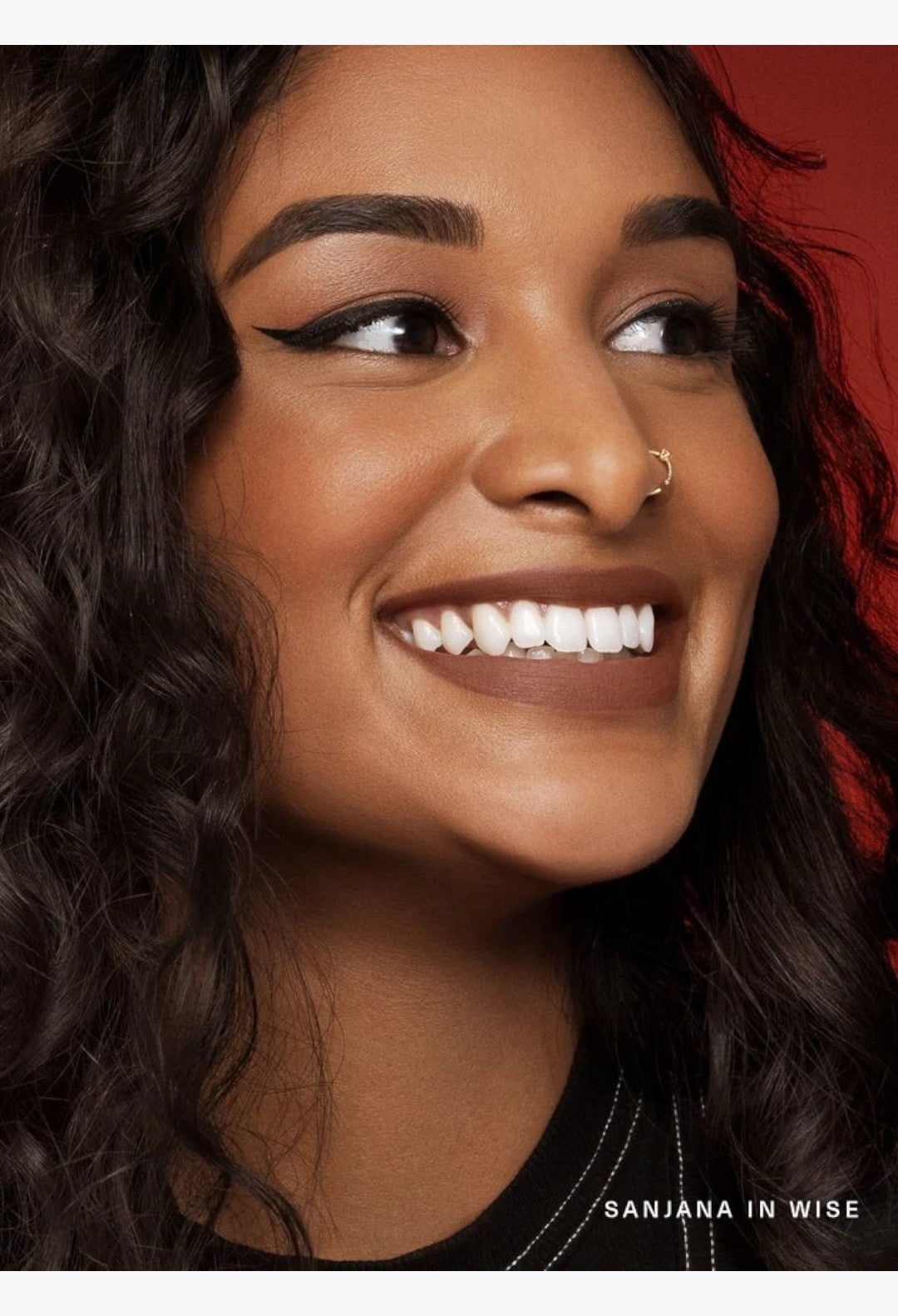GLAM MODA Kind Words Matte Lip Liner in Wise shade on a smiling model with warm brown nude lips and winged eyeliner