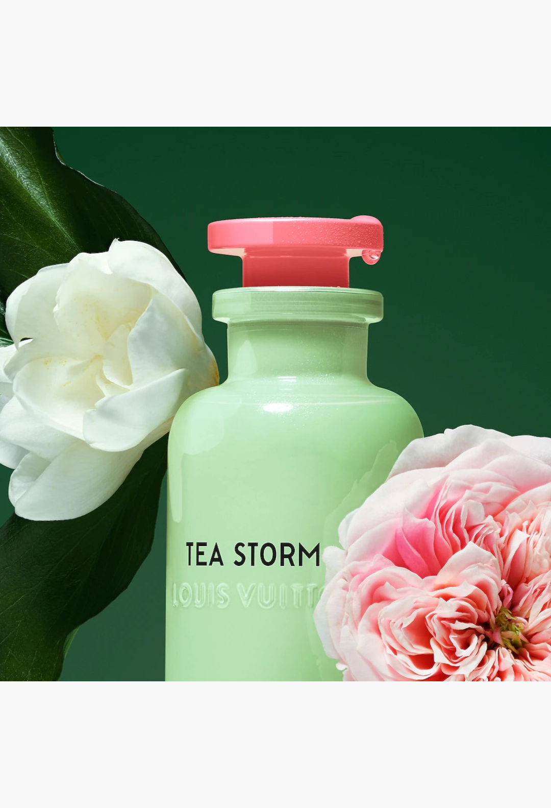 GLAM MODA Louis Vuitton Tea Storm perfume bottle in opalescent green glass with a pink cap, surrounded by flowers.