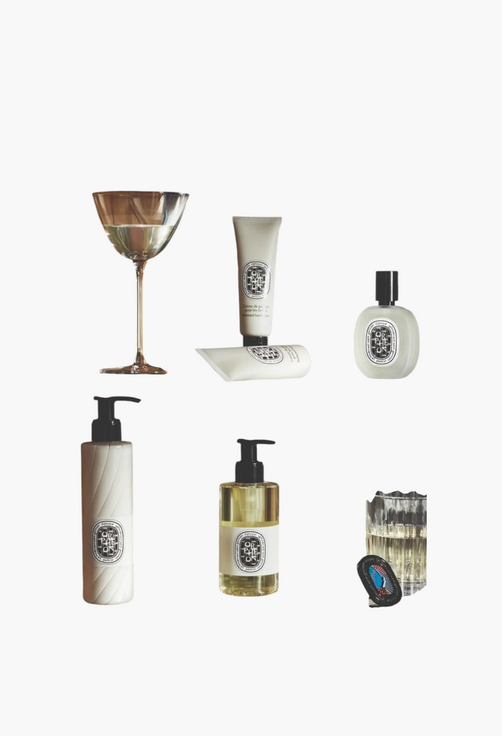 GLAM MODA Orphéon perfumed hand cream and fragrance collection displayed on a shelf with glassware in a bar setting.