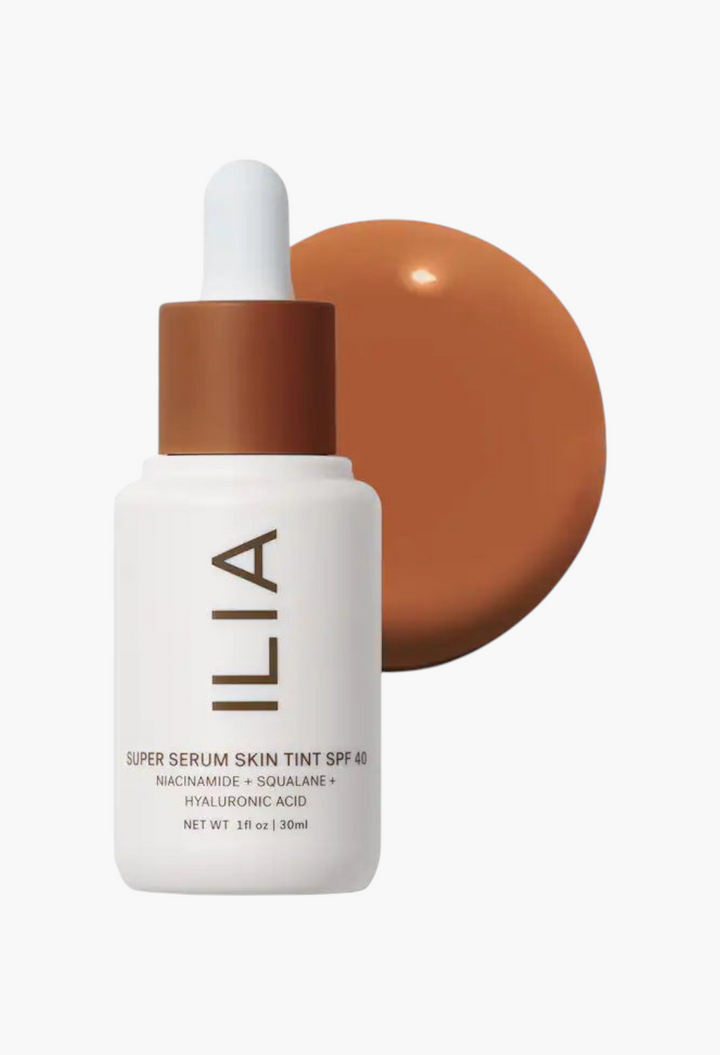 GLAM MODA ILIA Super Serum Skin Tint SPF 40 bottle with a brown liquid foundation swatch behind it.