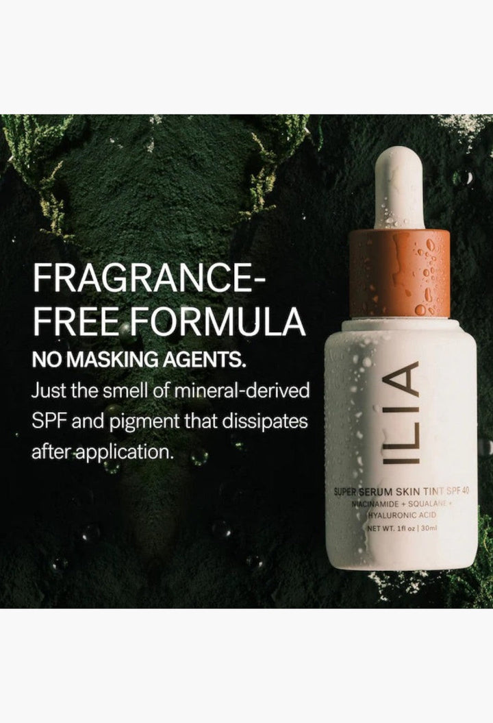 GLAM MODA ILIA Super Serum Skin Tint SPF 40 bottle with dropper on a dark green textured background