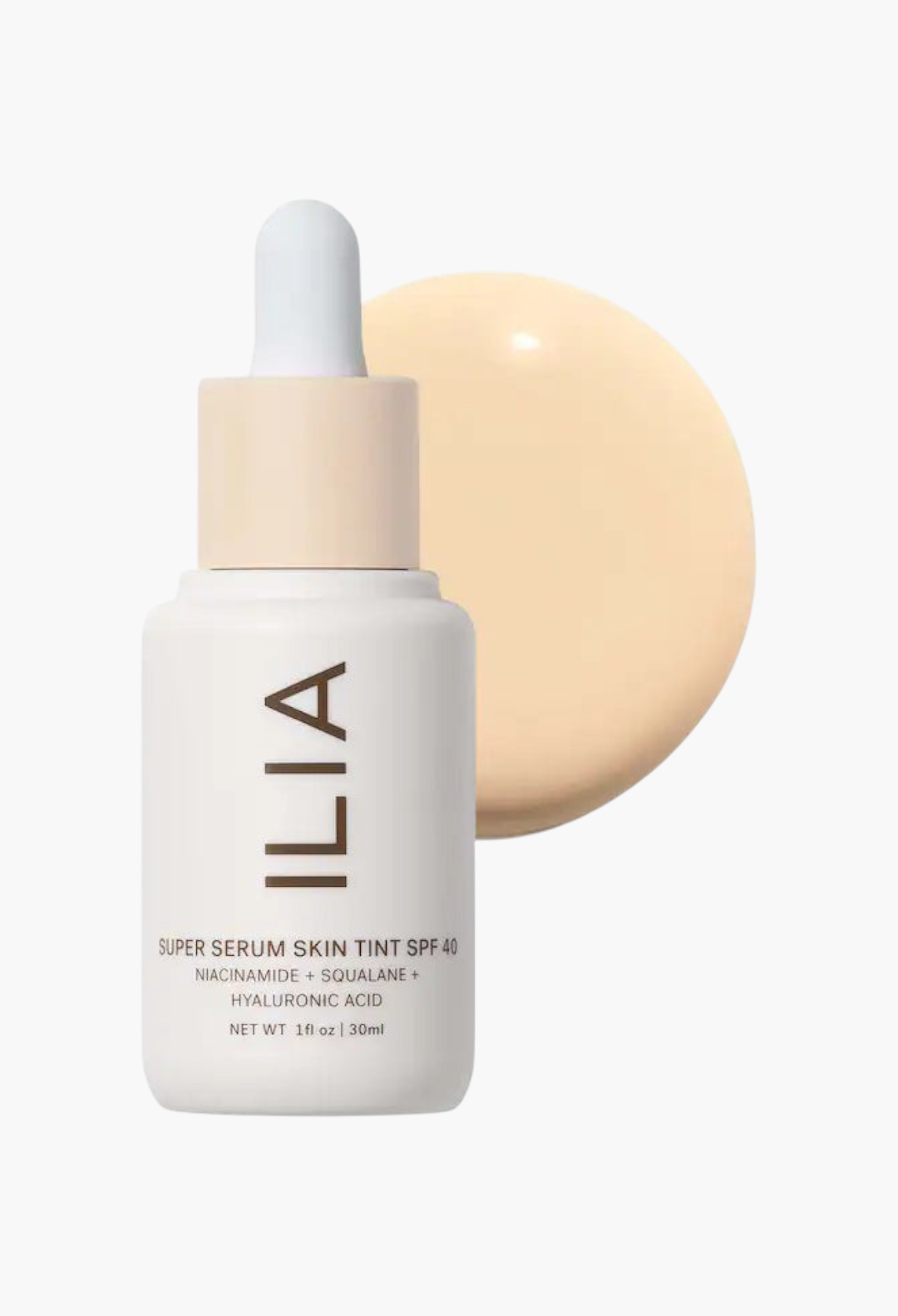 GLAM MODA ILIA Super Serum Skin Tint SPF 40 in a white dropper bottle with a swatch of liquid foundation behind it