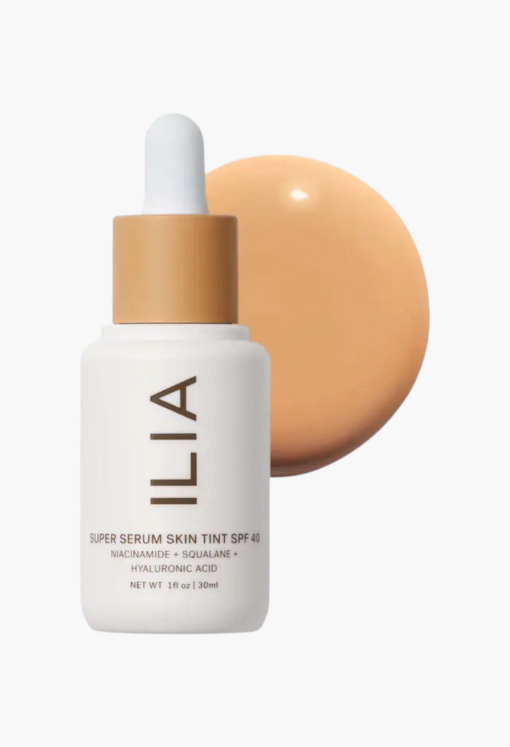 GLAM MODA ILIA Super Serum Skin Tint SPF 40 bottle with a swatch of liquid foundation behind it