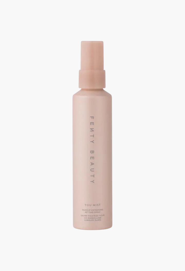 GLAM MODA Fenty Beauty You Mist makeup-extending setting spray in a tall, light pink pump bottle.