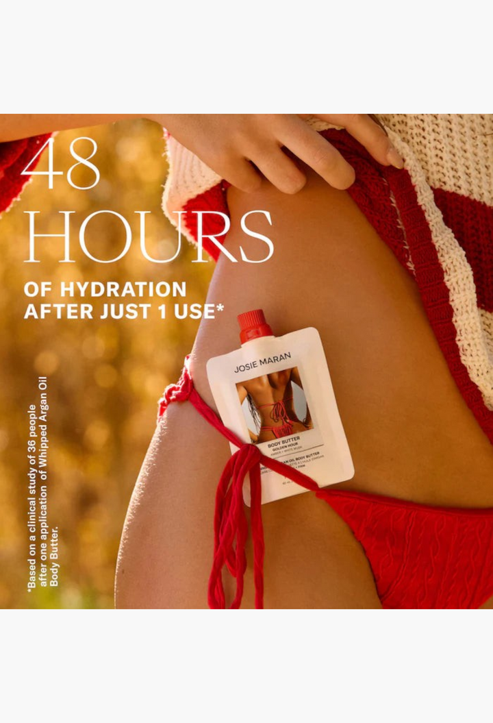 GLAM MODA Josie Maran whipped argan oil body butter travel pouch held against a woman in a red and white bikini