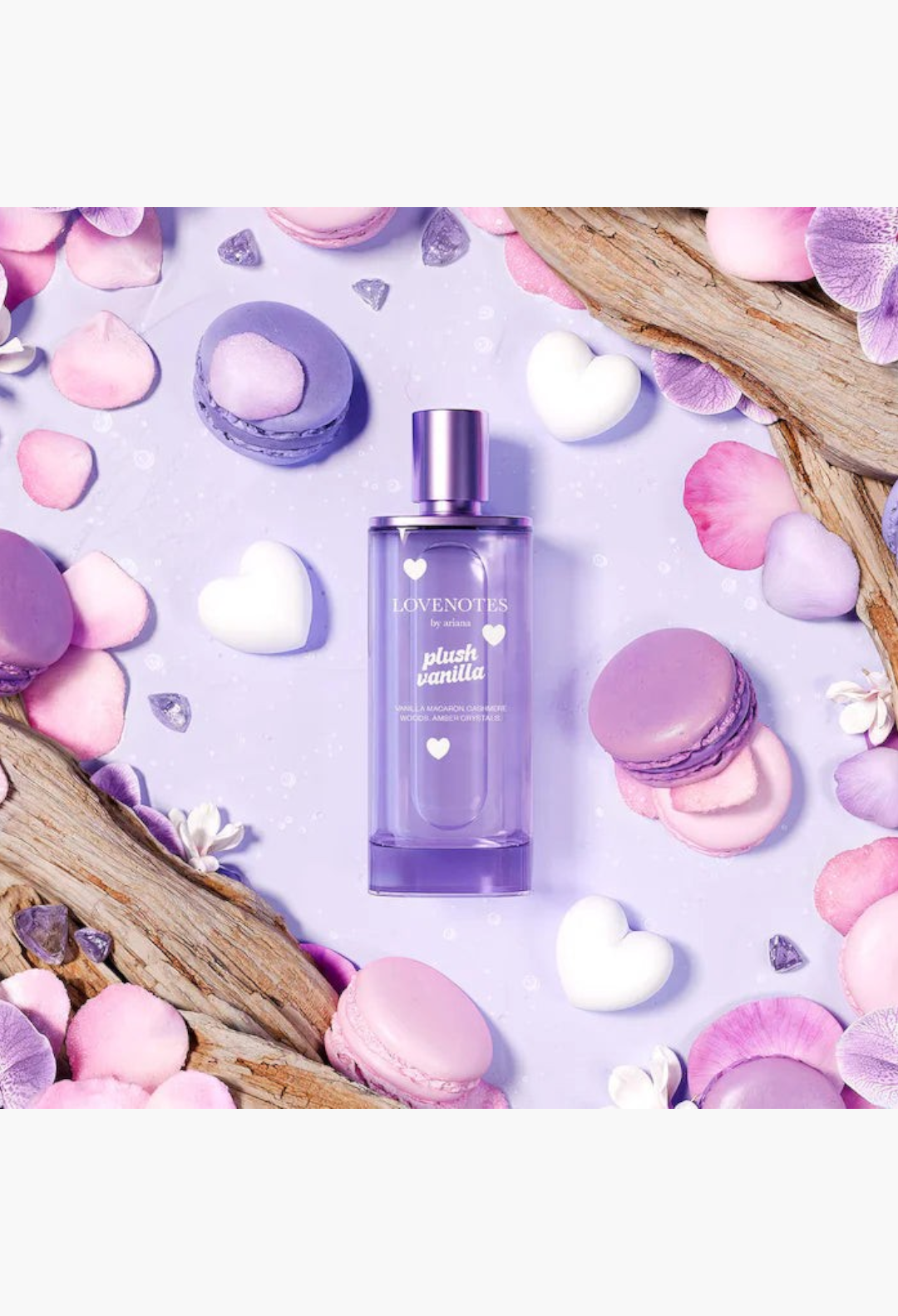 GLAM MODA Ariana Grande Lovenotes Plush Vanilla perfume bottle surrounded by purple macarons, flower petals, and hearts.